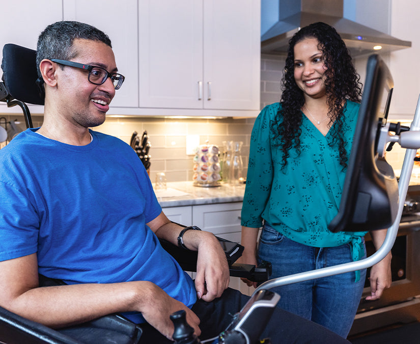 A man in a wheelchair using his communication device in the kitchen