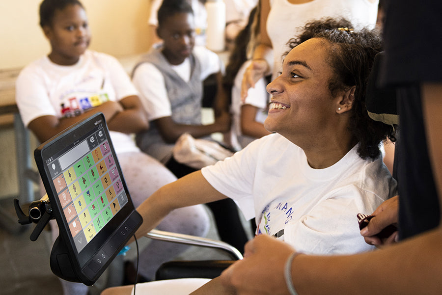 Jeune femme atteinte d'infirmité motrice cérébrale utilisant l'application TD Snap AAC sur un appareil générateur de parole.